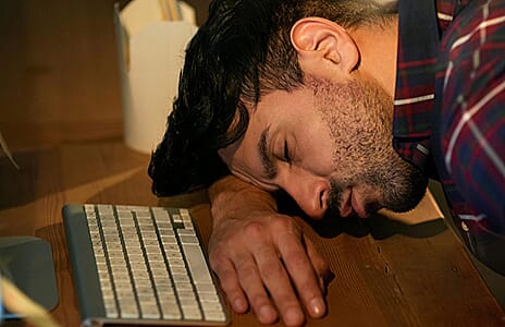 Tired person in their 40s struggling with low energy and fatigue — NAD+ decline causes cellular energy depletion