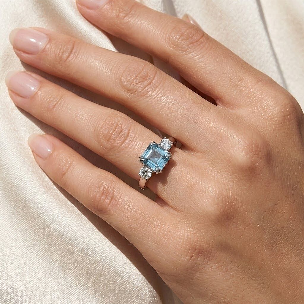 Luxuriant Lab Grown Diamond & Blue Zircon Three-Stone Emerald Cut Ring in Rhodium Overlay Sterling Silver 1.61 Ct.